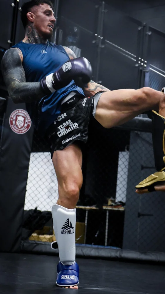 Athlete practising a kick in the training cage