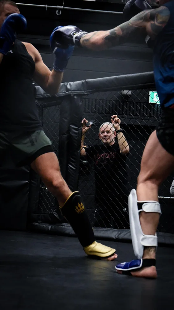Athletes sparring inside the training cage