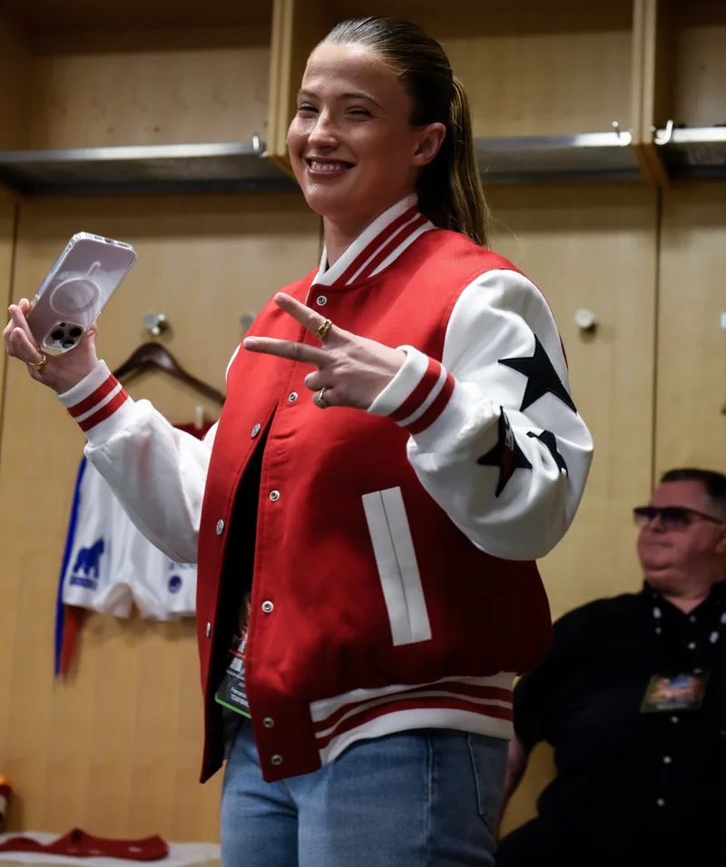 Athlete smiling backstage in a red and white jacket