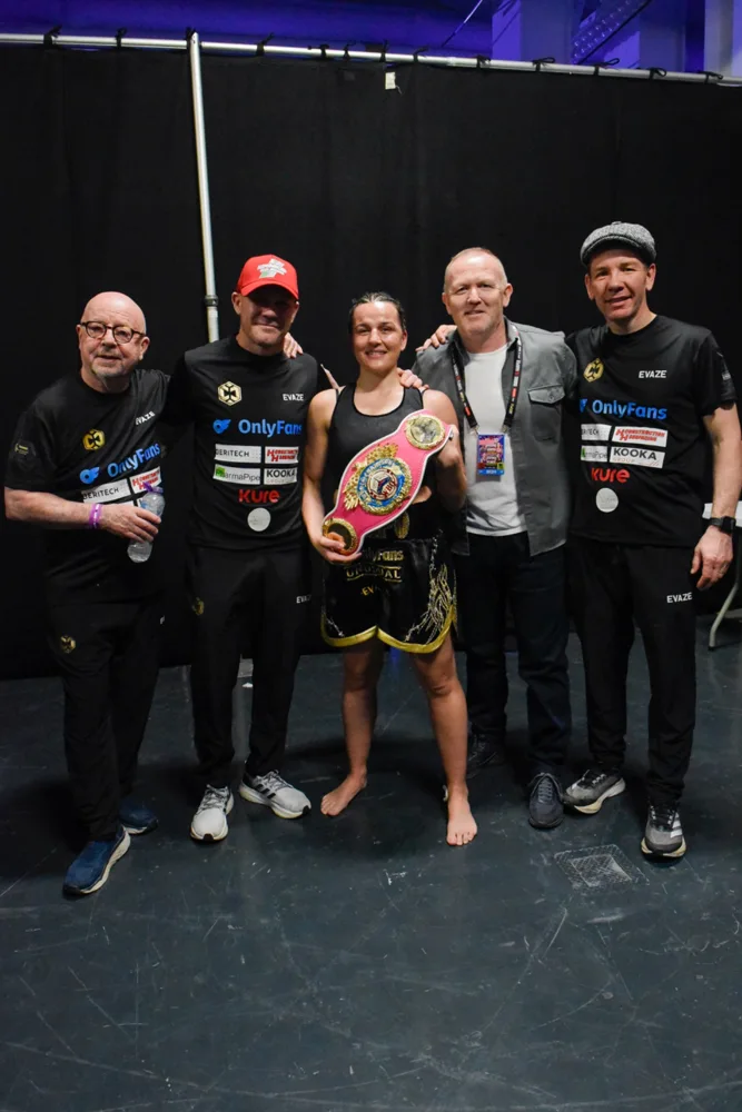 Boxer holding a championship belt with their team