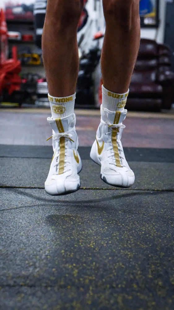 Close-up of white and gold boxing boots during footwork training
