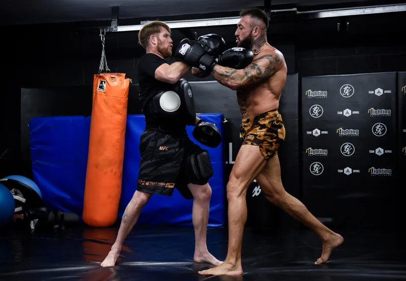 Combat sports athlete working pads on the gym floor