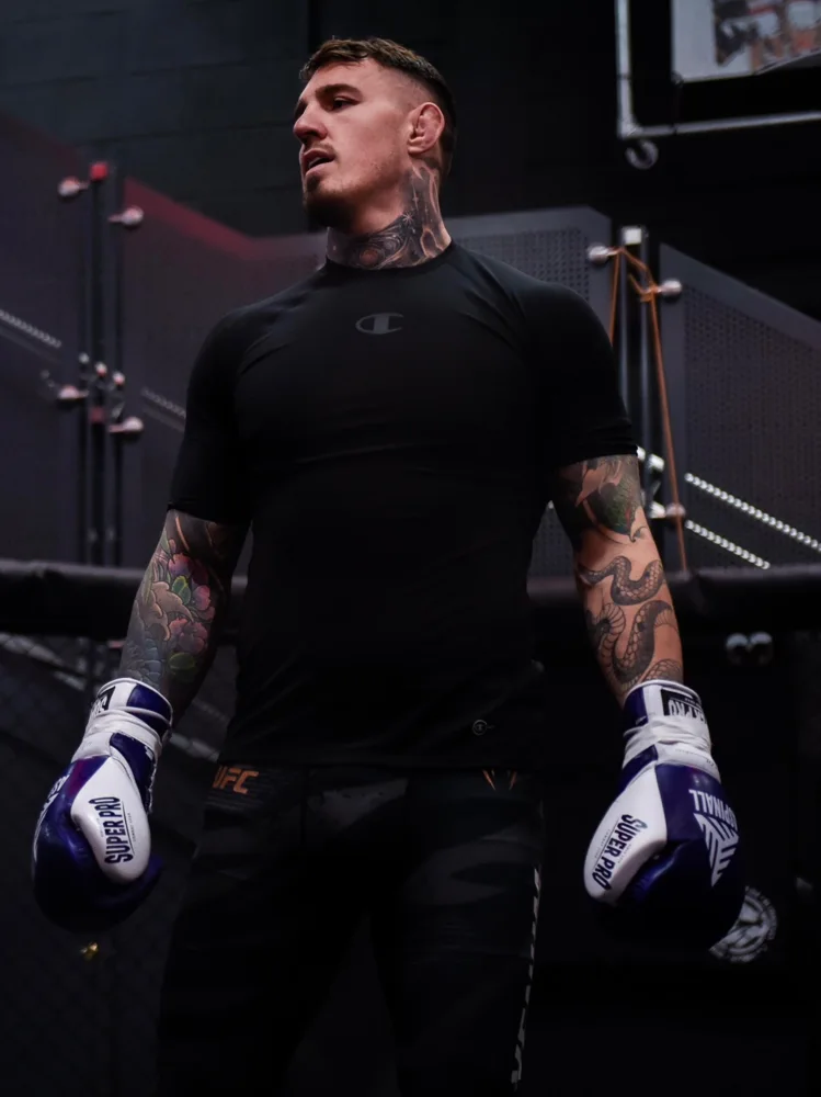 Athlete showcasing a black training shirt and boxing gloves