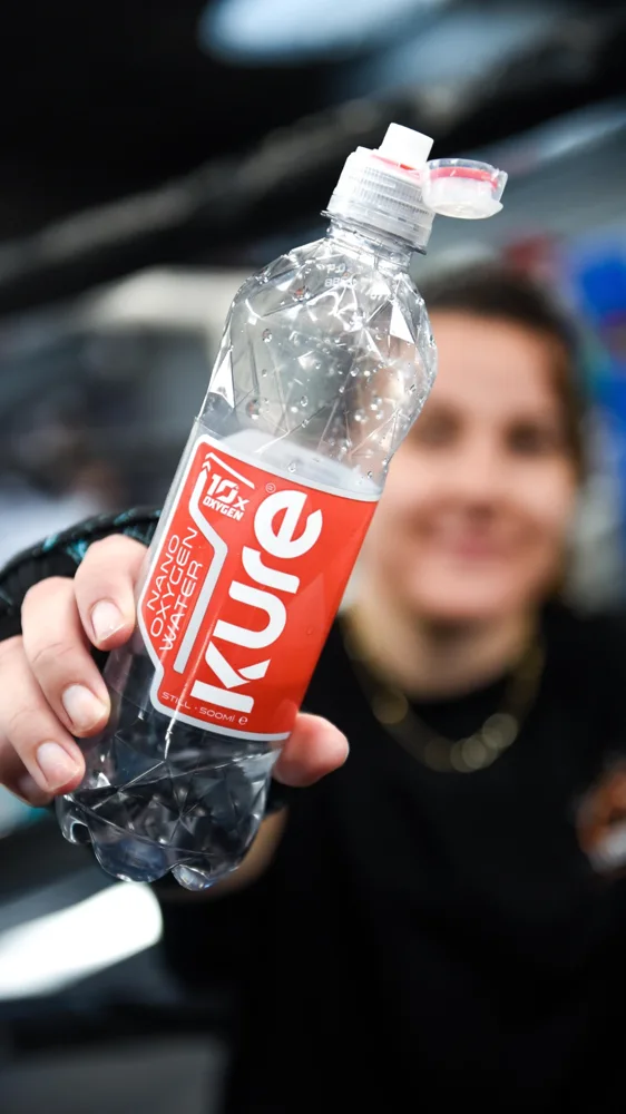 Athlete holding a Kure water bottle