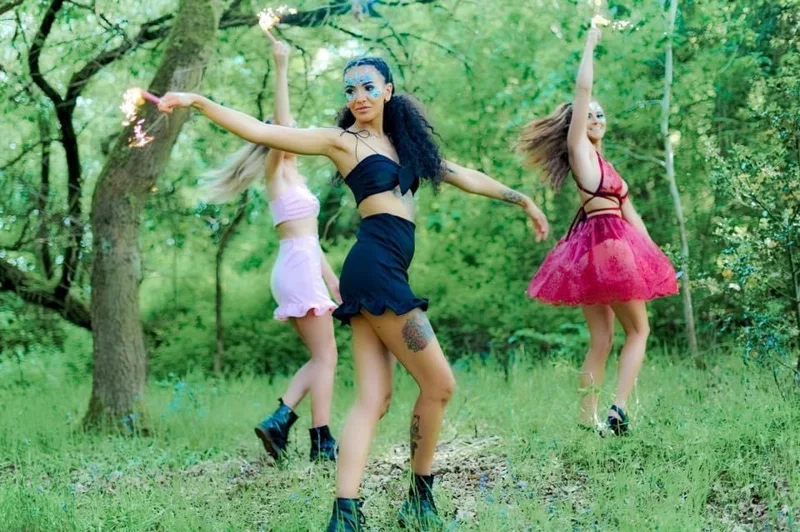 Models in festival outfits with sparklers in woodland