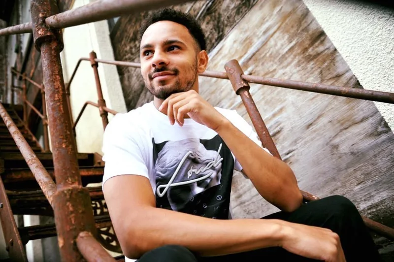 Model wearing a white graphic T-shirt on outdoor steps