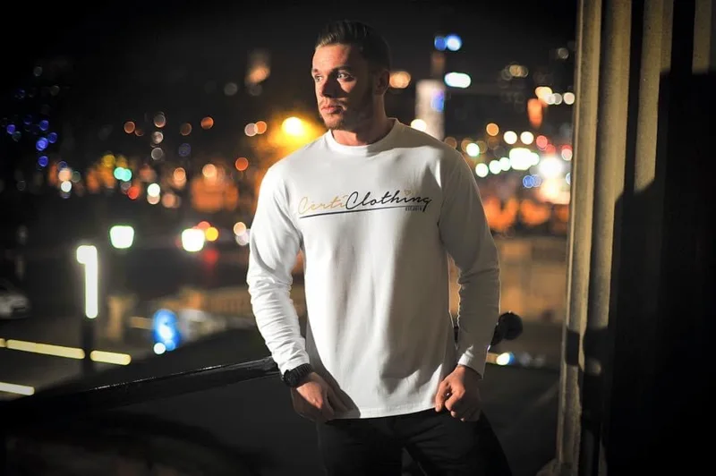 Model wearing a white branded long-sleeve shirt at night