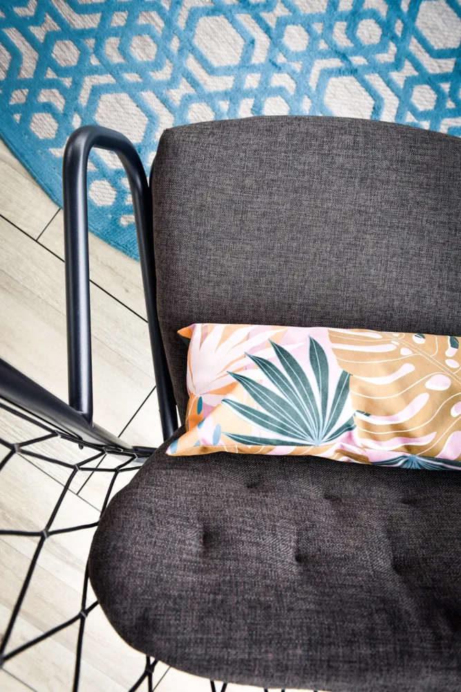 Outdoor chair with a patterned cushion and blue rug
