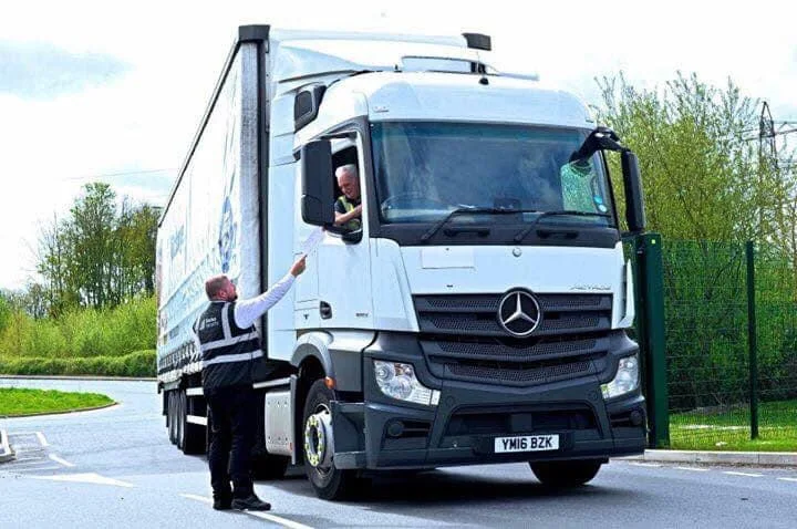 Logistics staff beside a delivery lorry