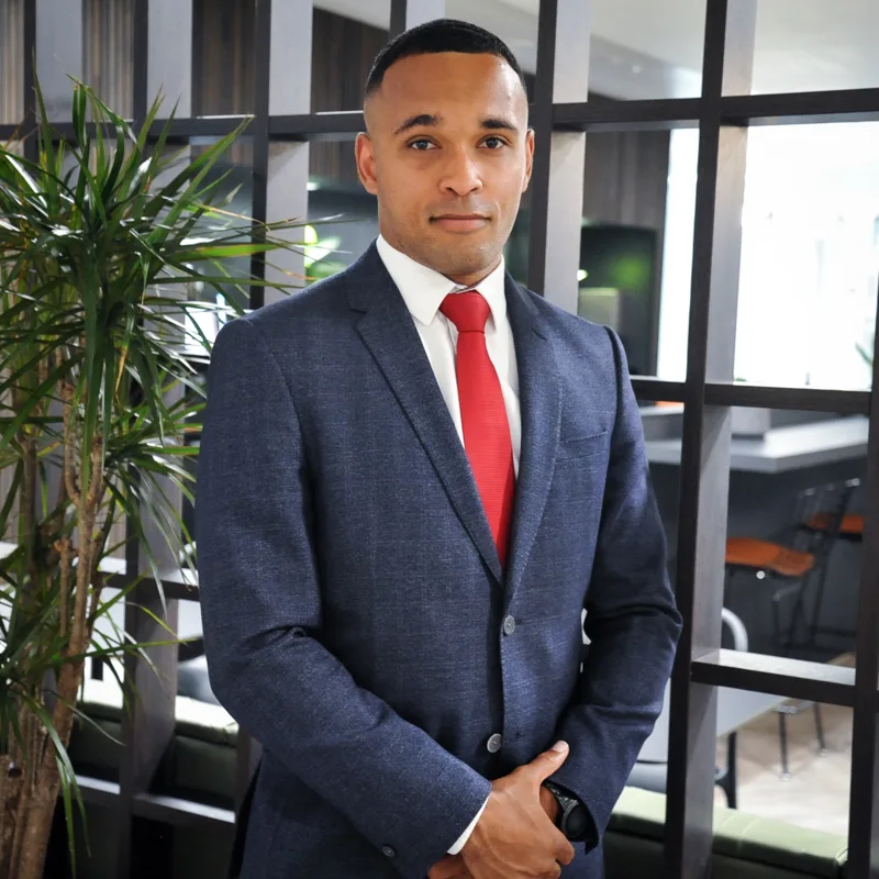 Corporate portrait of a team member in a blue suit and red tie