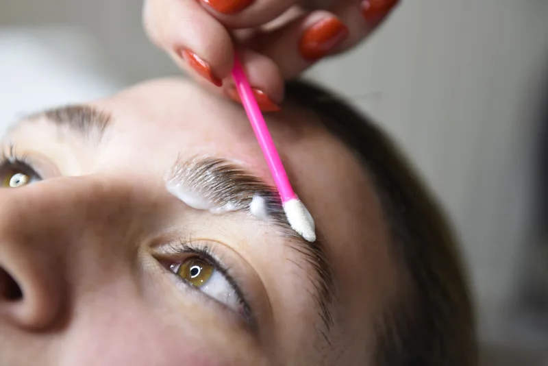 Beauty professional applying an eyebrow treatment