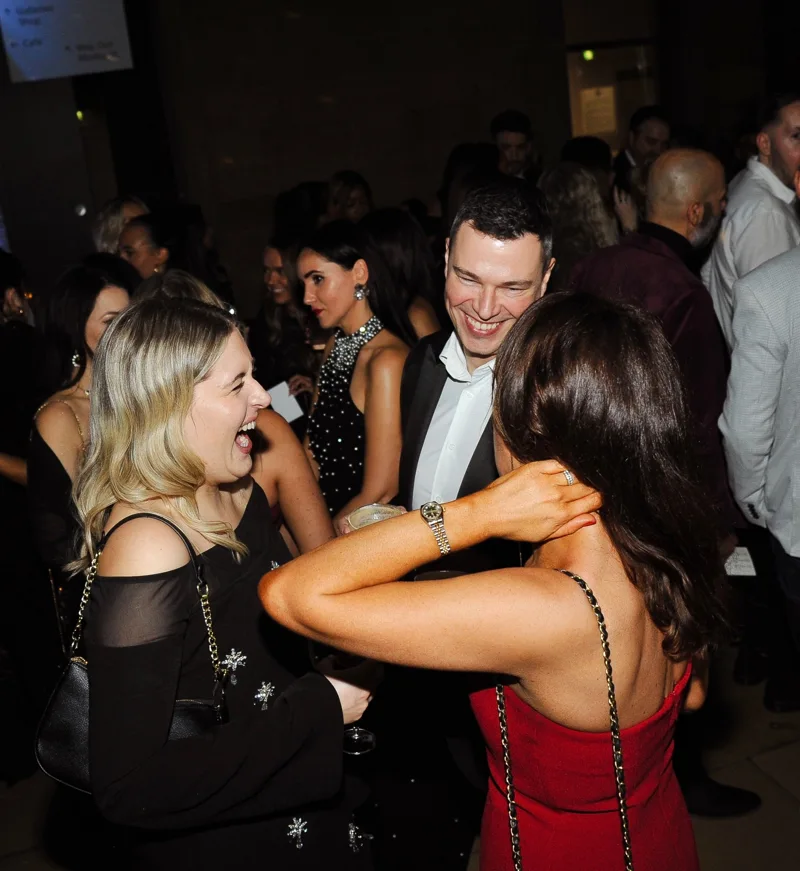 Guests laughing and talking at a party