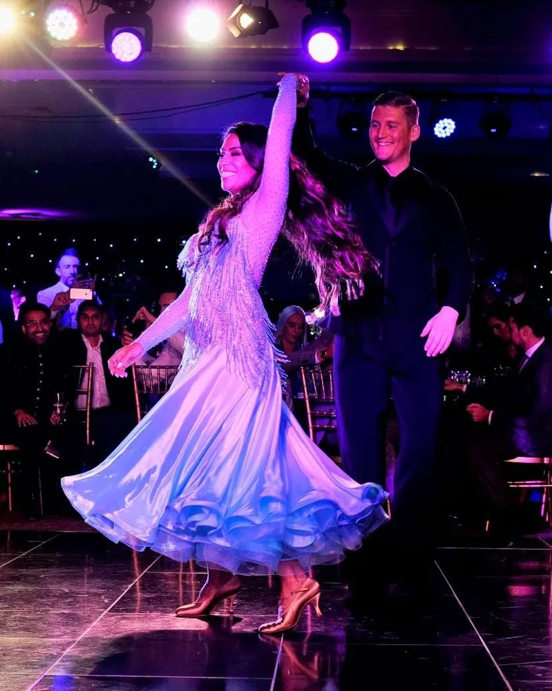 Dancing couple under purple stage lights