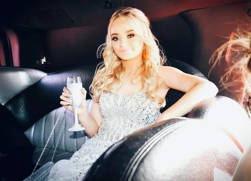 Guest seated in a limousine holding a champagne glass