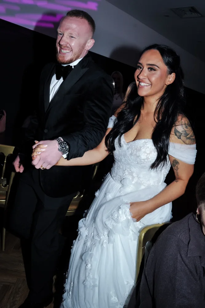 Newlyweds holding hands at their wedding reception
