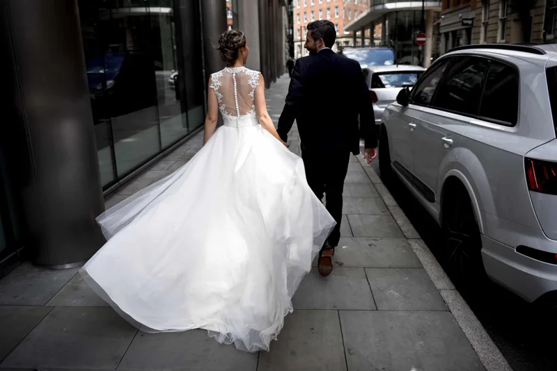 Newlyweds walking hand in hand through the city